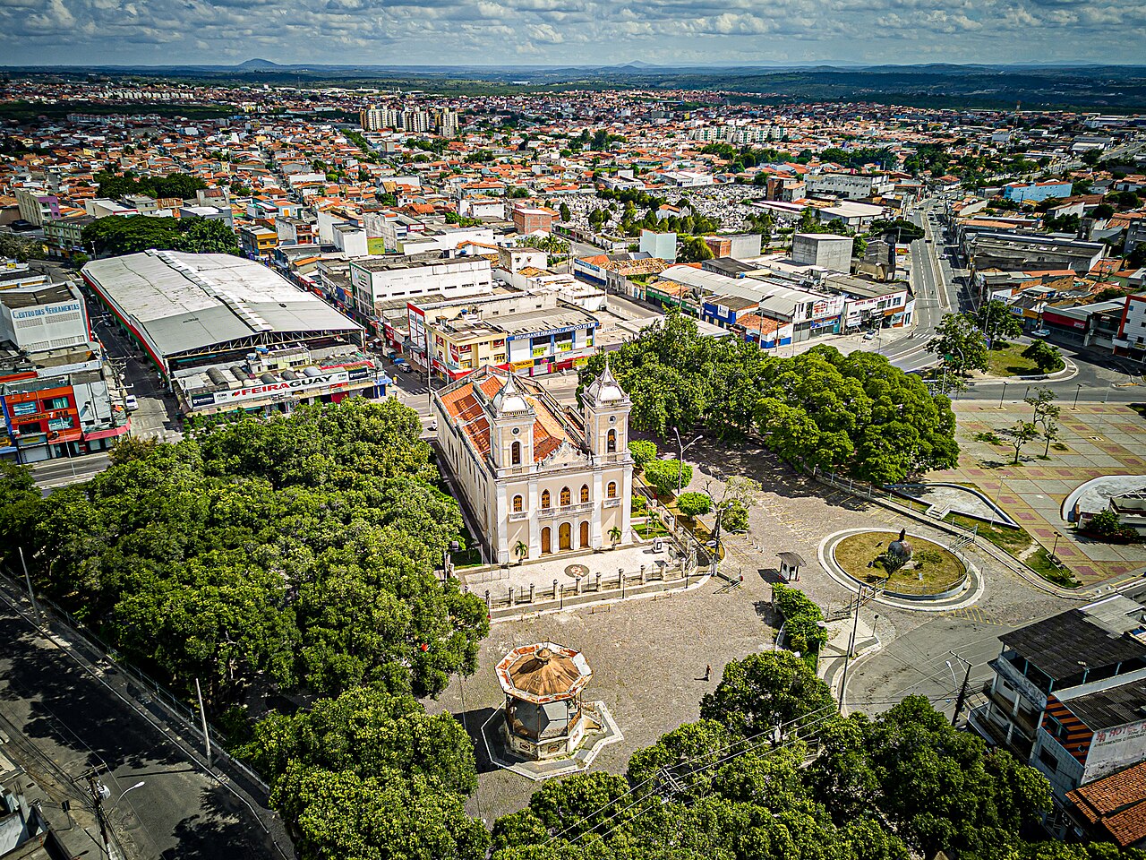 Vista aérea da Catedral Metropolitana de Sant'Ana e da Praça da Matriz, no centro de Feira de Santana, Bahia, com casas e prédios ao redor